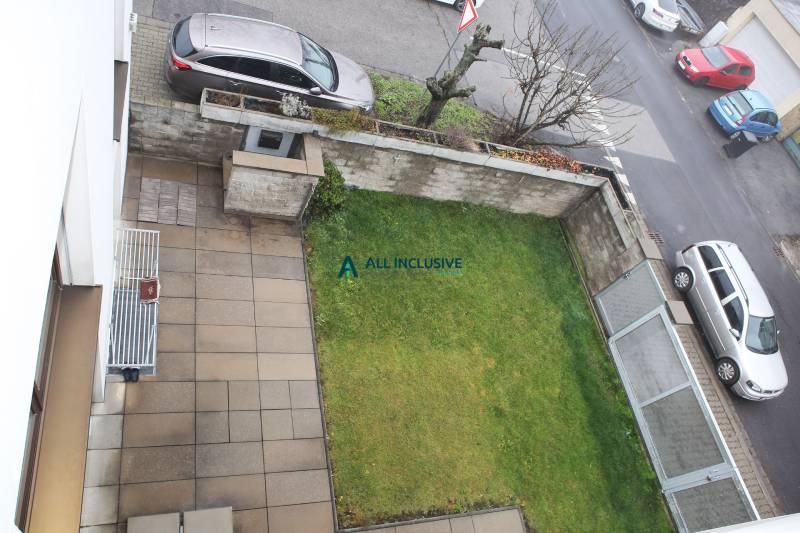 Kilátás egy családi ház kertjére és teraszára az utcai parkolással a Súľovská utcában.