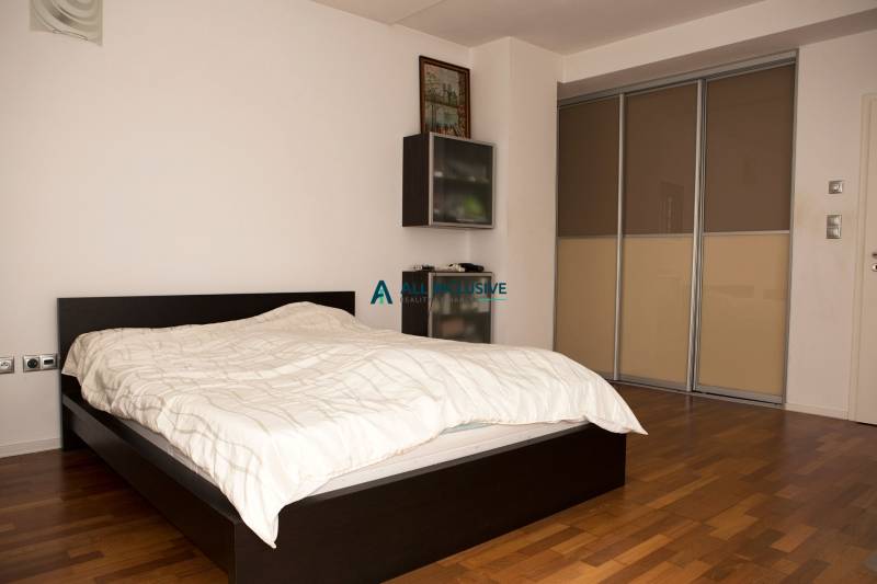 Hálószoba családi házban ággyal és szekrénnyel, fa dekoros padlóval.