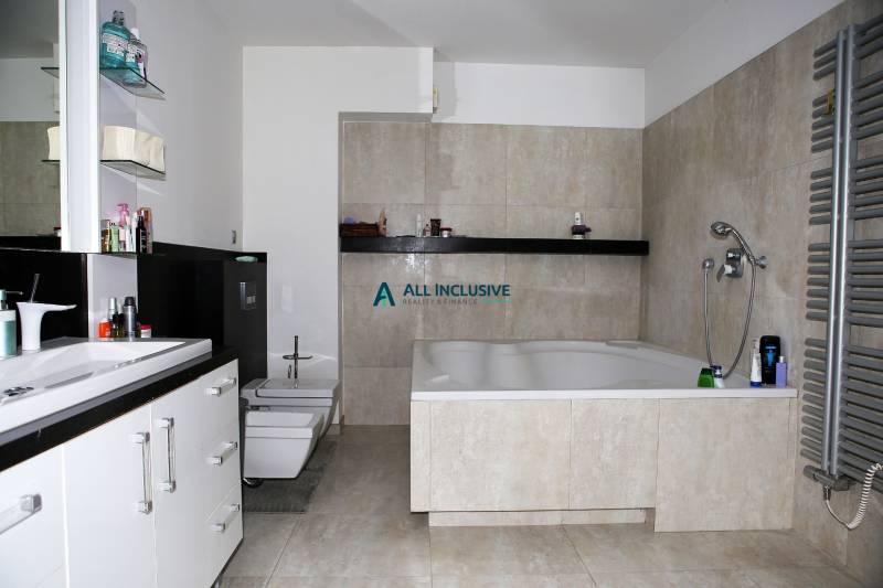 Fürdőszoba nagy káddal és világos csempékkel egy családi házban.