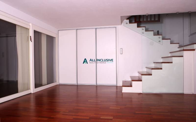 Családi ház belső tere fa dekorációjú padlóval és üvegkorlátos lépcsővel.