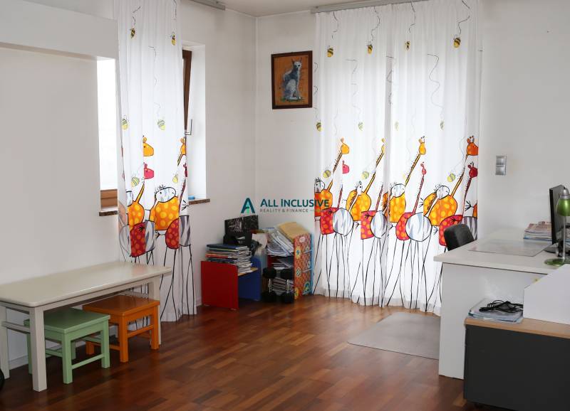 Gyerekszoba egy családi házban színes függönyökkel és fa dekorációjú padlóval.