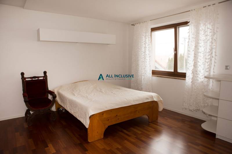 Hálószoba családi házban ággyal, székkel és fa dekorációjú padlóval.