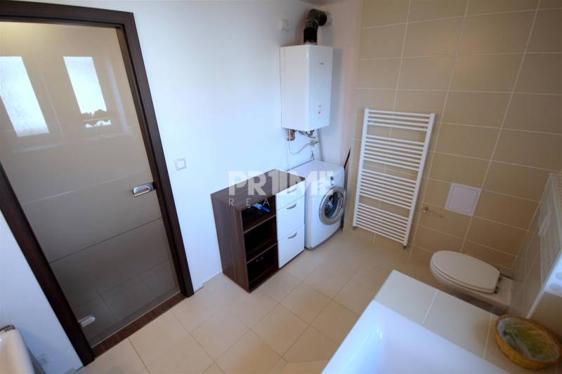 Fürdőszoba káddal, mosdóval, mosógéppel és szekrényekkel egy kétszobás lakásban.