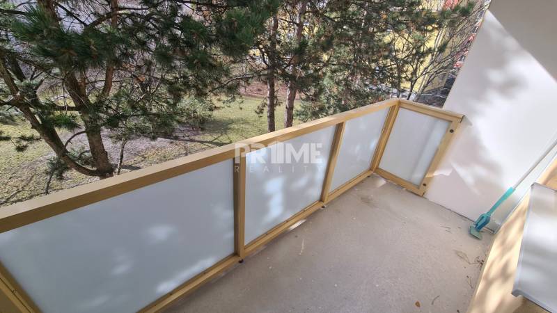 2 szobás lakás erkélye kilátással a zöldre, átlátszó korláttal.