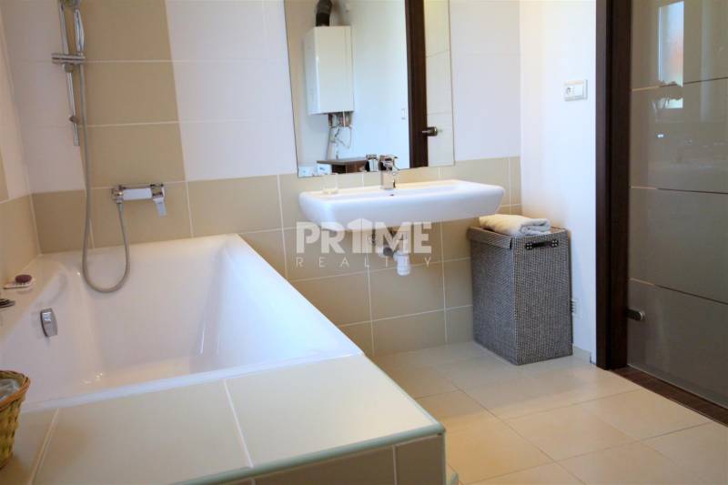 Fürdőszoba káddal, mosdóval és mosókosárral egy kétszobás lakásban.