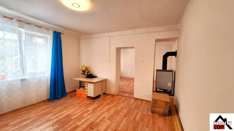 Családi ház fa mintázatú padlóval, függönyös ablak és íróasztal.