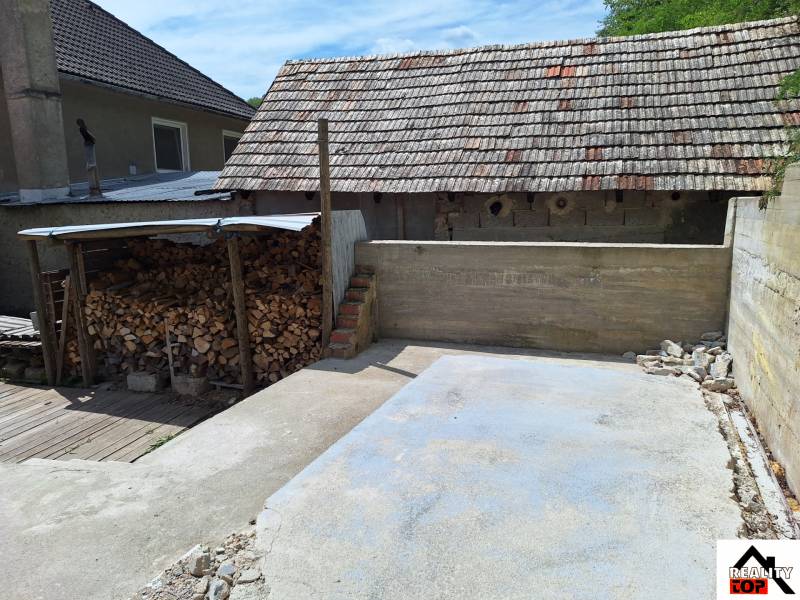 A Hajnáčkai családi ház udvara fatárolóval és betonterülettel.