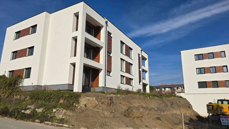 Új épületek a Banka utcában Pöstyénben fehér homlokzattal és fa dekorációval kombinálva.