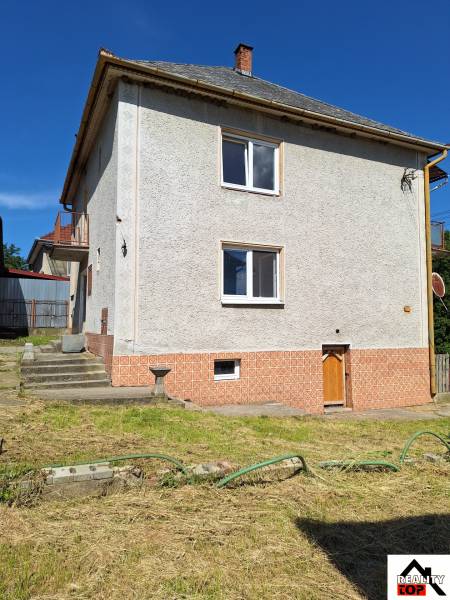 Családi ház Sídon meredek tetővel és gondozott kerttel, gyepesítve.