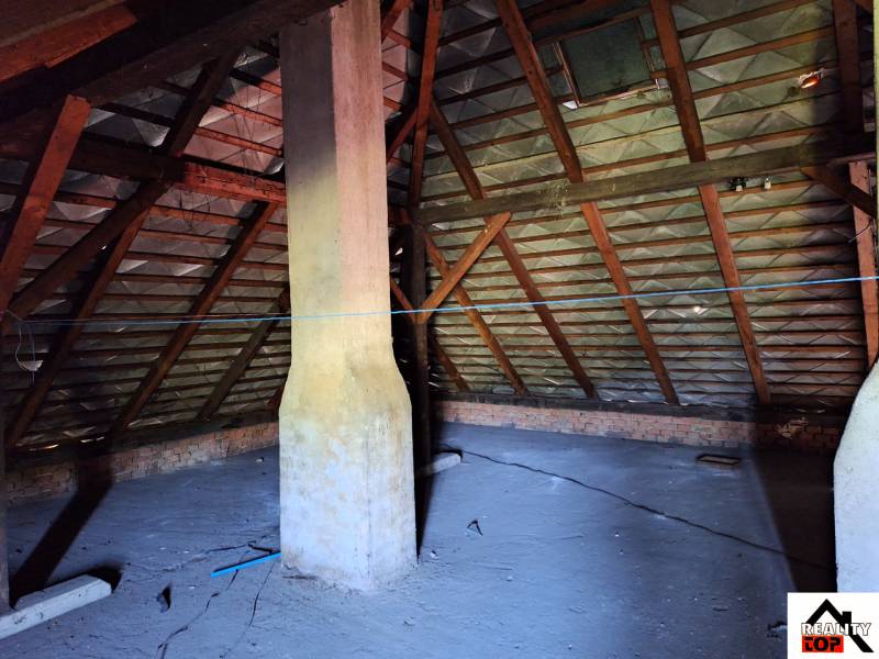 A sídi családi ház padlása fagerendákkal és kéménnyel.