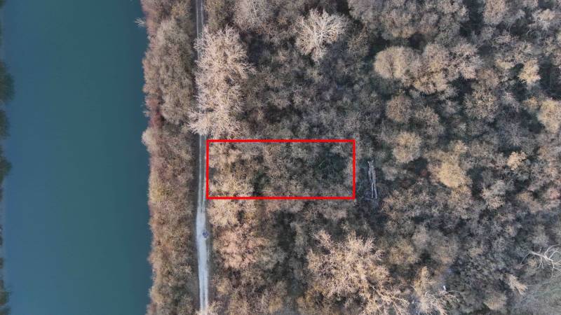 Légi felvétel a rekreációs területekről Újfaluban, amelyeket erdő és folyó vesz körül.