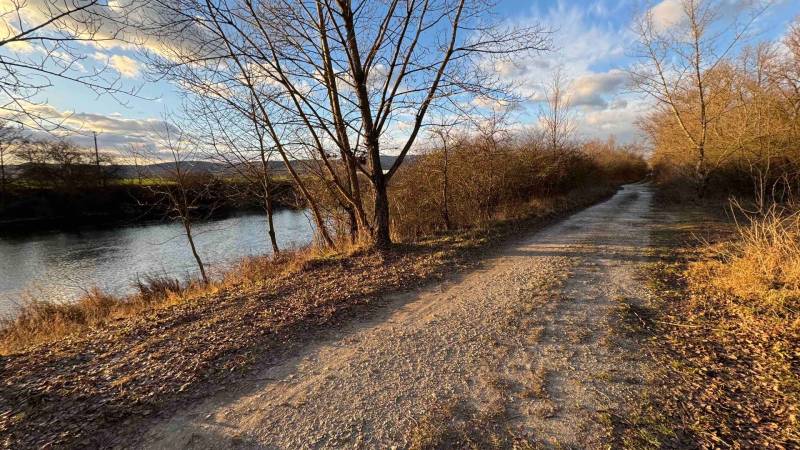 Rekreációs telkek Újfalunál természetes úttal és folyóval ősszel.