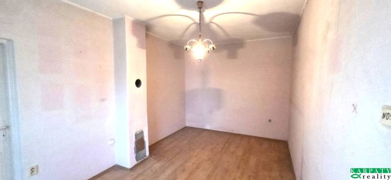 Szoba egy családi házban fa dekorációjú padlóval és függőlámpával.