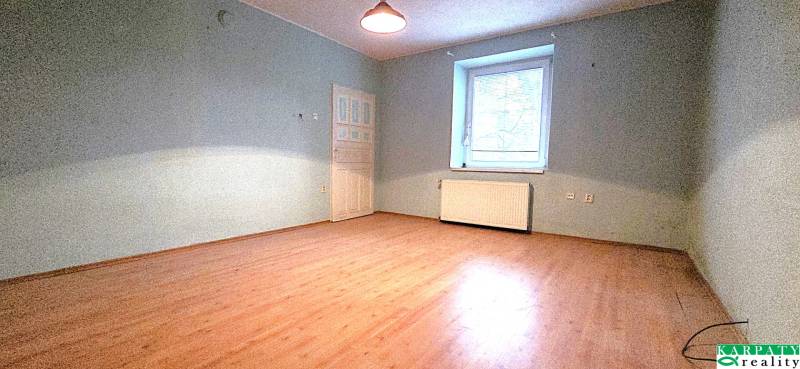 Szoba családi házban fa dekorációjú padlóval és kék falakkal.