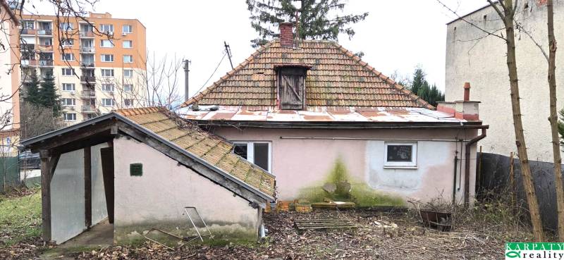 Családi ház az Augusztus 29. utcában, Lévában, kopott homlokzattal és kerttel.