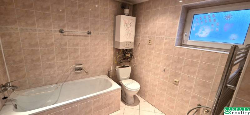 Fürdőszoba családi házban káddal, WC-vel és fali fűtéssel.