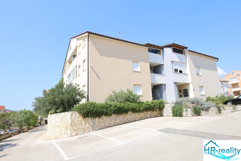 Nyaraló apartman Vodice városában zöldövezettel, kőfallal és parkolóhelyekkel.