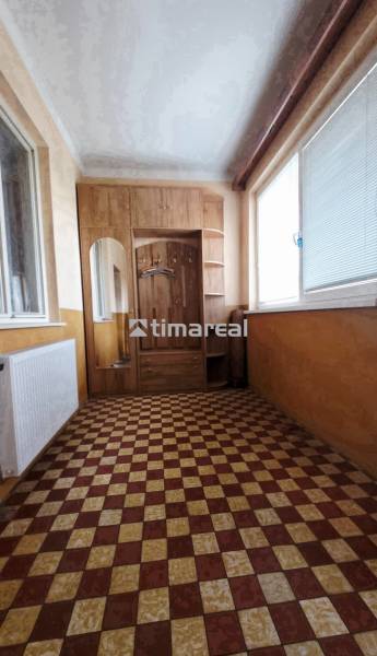 Folyosó egy családi házban csempével, tükörrel és nagy ablakkal.