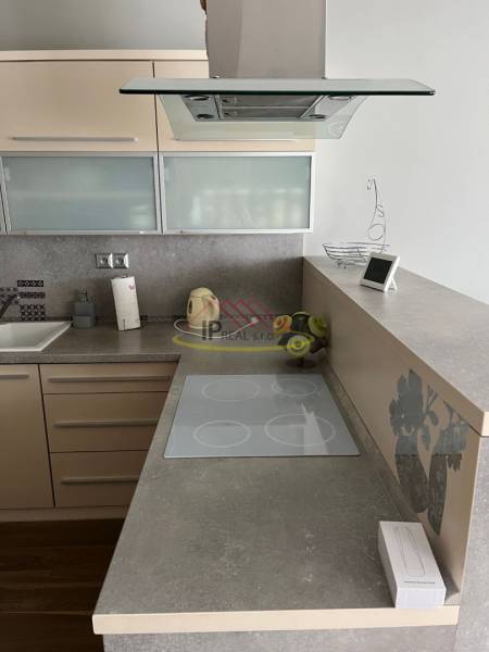 Konyhapult a négyszobás lakásban indukciós főzőlappal és páraelszívóval.