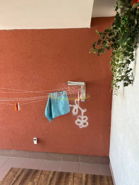 Erkély egy 4 szobás lakásban színes fallal, fehér grafittal és fa dekor padlóval.