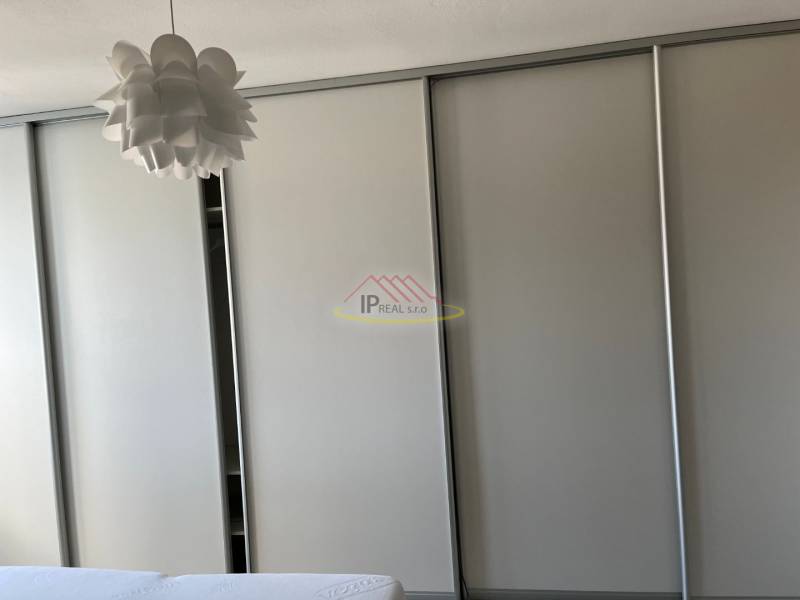 Beépített szekrény világos dekorral és eredeti mennyezeti csillár a 4 szobás lakásban.