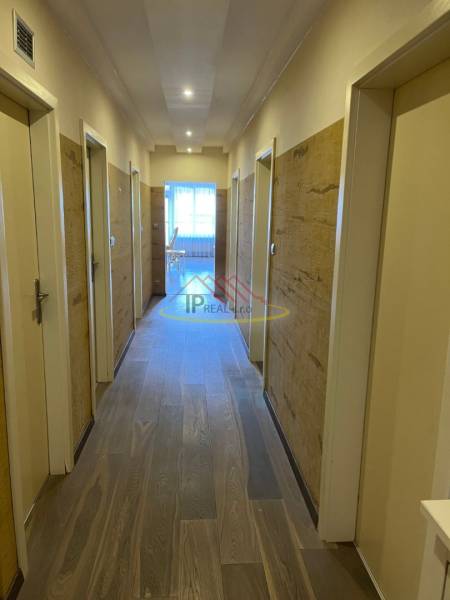 Folyosó a 4 szobás lakás szobáinak bejáratával, fa dekorációjú padlóval.