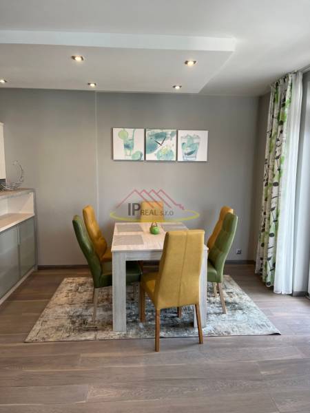 Étkező sarok egy 4 szobás lakásban színes székekkel és fa mintázatú padlóval.