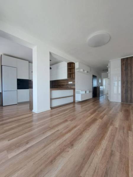 2 szobás lakás belső tere fa dekor padlóval és beépített szekrényekkel.