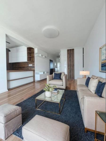 Nappali egy kétszobás lakásban, fa mintázatú padlóval és kényelmes kanapékkal.