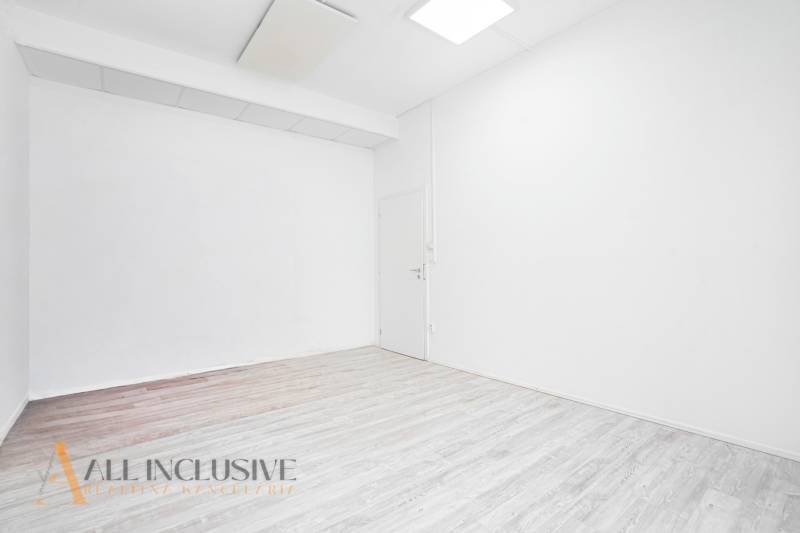 Fehér falakkal és fa dekorációjú padlóval rendelkező belső tér egy irodában.