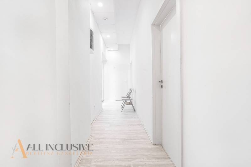 Világos folyosó fa padlóval és székkel az irodában.