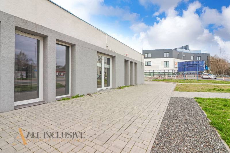 A Vajanského utcán, modern építészetű üzlethelyiségek mellett, szilárd burkolatú járdákkal.