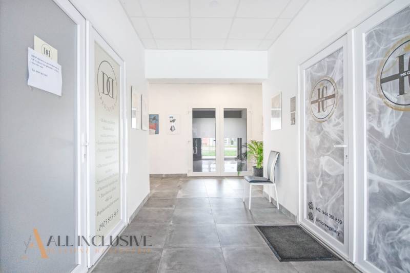 Világos belső tér üzlethelyiségek ajtajával a Vajanského utcán, növények jelenlétével.