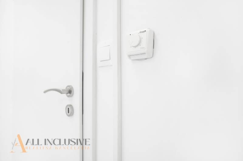 Fehér fal termosztáttal és kilinccsel az irodában.