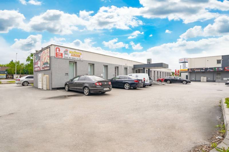 Épületek a Galántai Clementis Ligetben irodák előtt parkoló járművekkel.