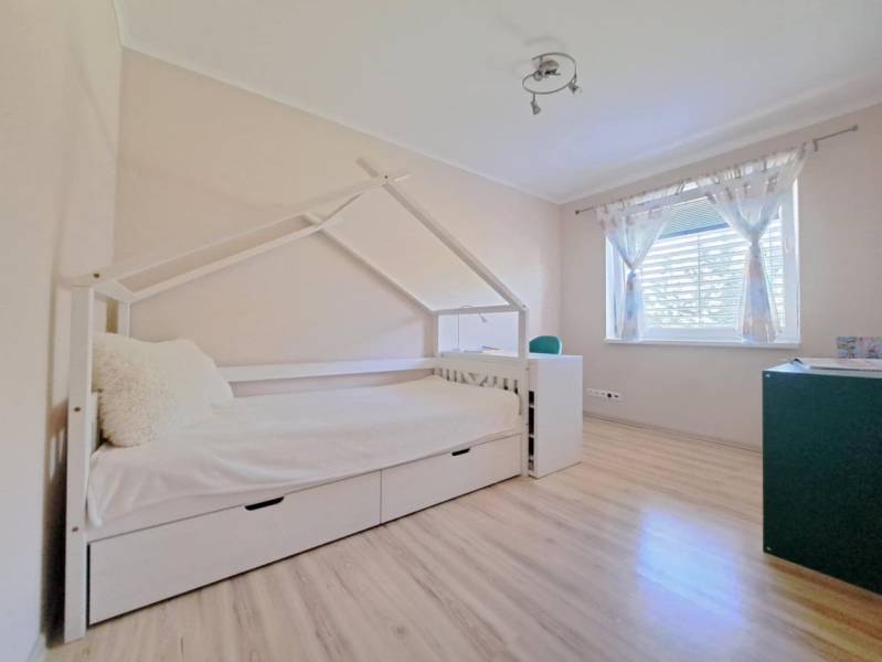 Gyerekszoba családi házban, házikó alakú ággyal és fa dekorációjú padlóval.