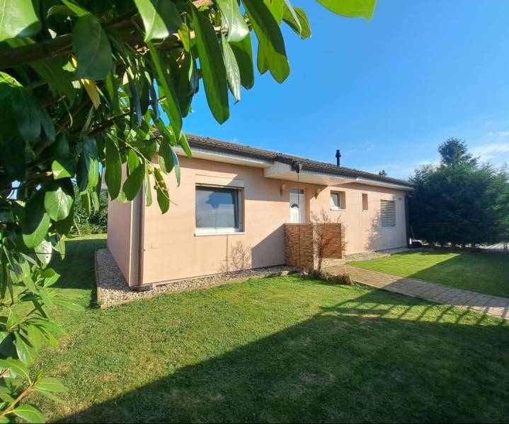 Családi ház Feketeváron, zölddel és gondozott gyepfelülettel körülvéve.