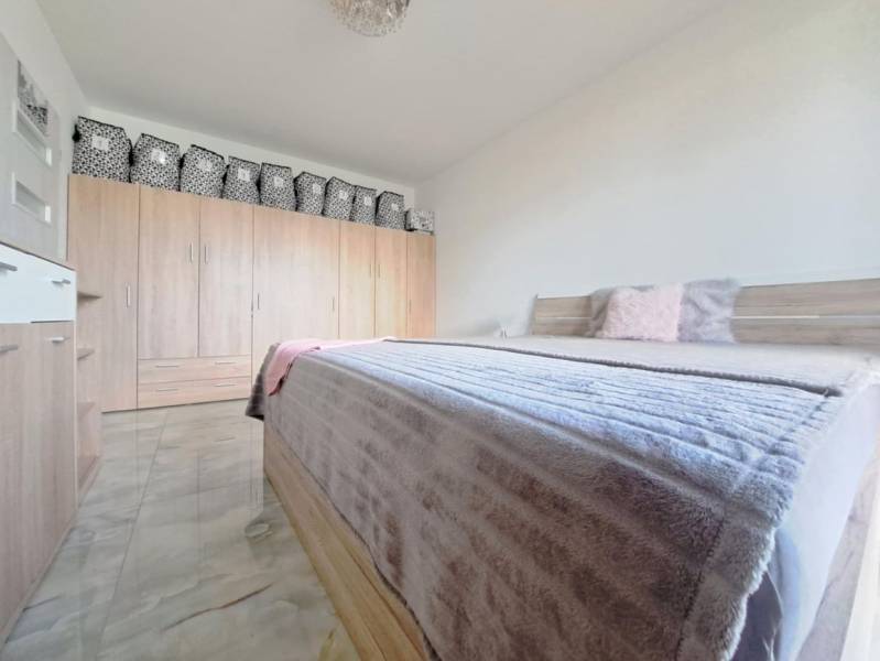 Hálószoba családi házban franciaággyal, szekrénnyel és fa dekorációjú padlóval.