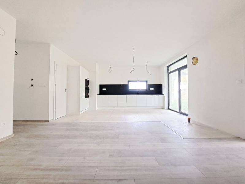 Tágas konyha fekete burkolattal és fa dekorációjú padlóval egy családi házban.