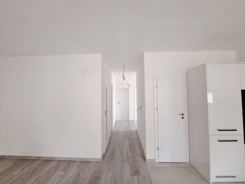 Világos családi ház belső tér fa dekorációjú padlóval és fehér falakkal.