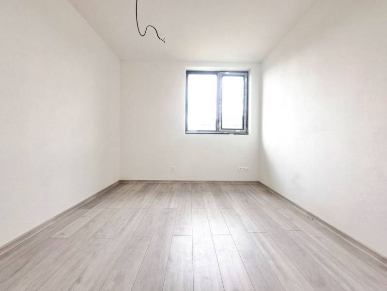 Üres szoba fa mintázatú padlóval és ablakkal egy családi házban.