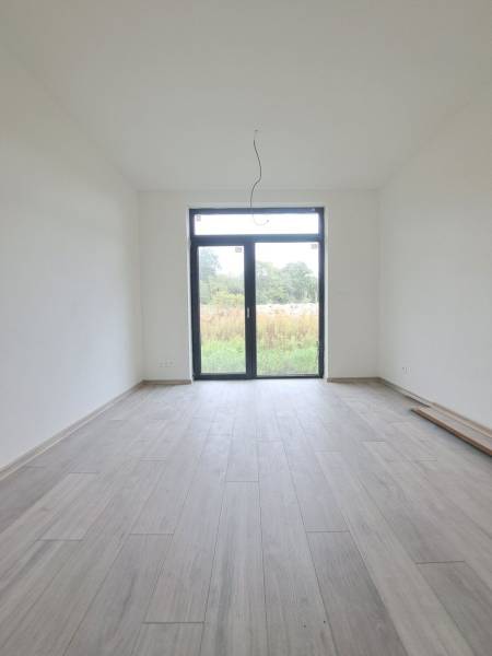 Családi ház belső tere fa dekorációs padlóval és nagy ablakkal.