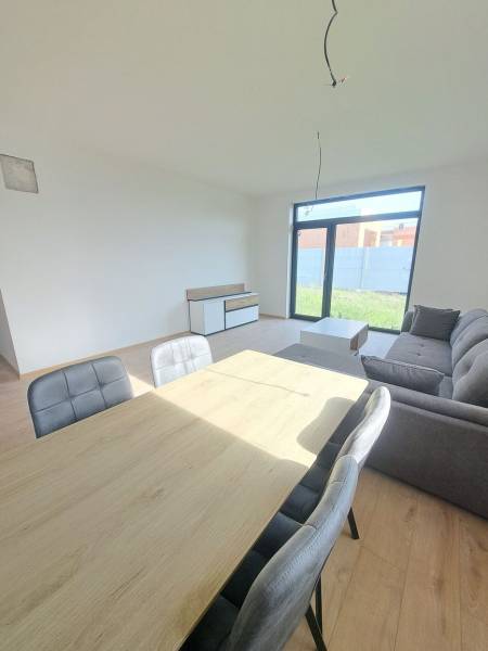 Ebédlő egy családi házban kanapéval és fa dekor padlóval.