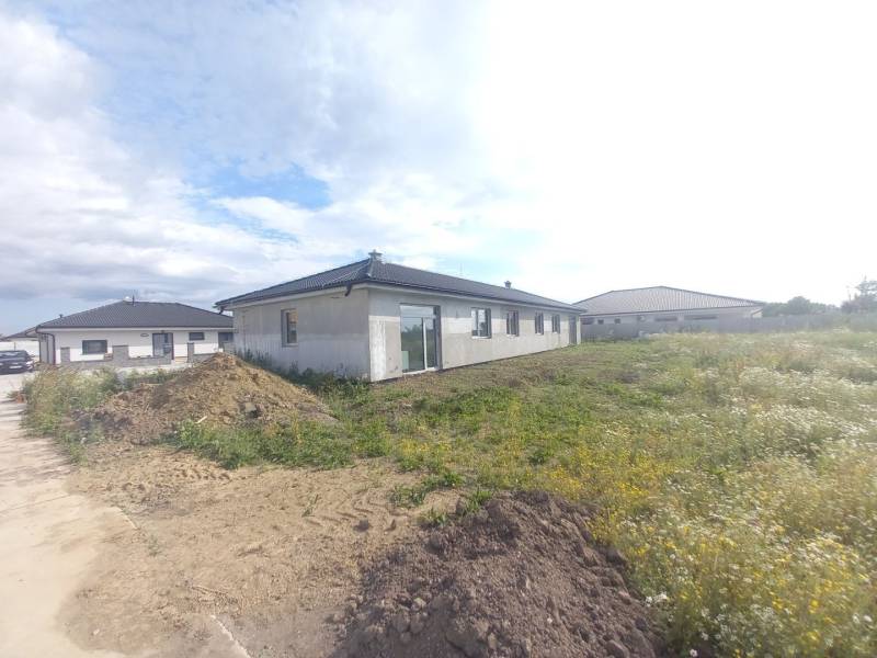 Családi ház építése Galántán, körülvéve a hozzá tartozó telekkel és további házakkal.