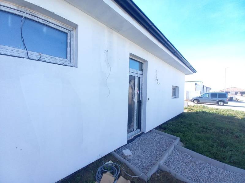 Családi ház Galántán, fehér homlokzattal és térkővel a előkertben.