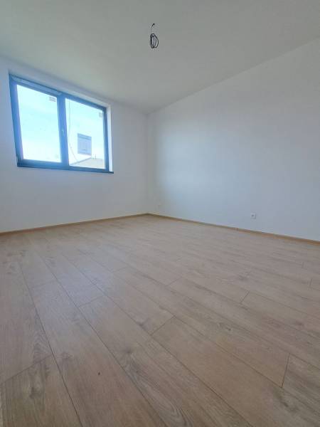 Szoba egy családi házban fa dekoros padlóval és nagy ablakkal.