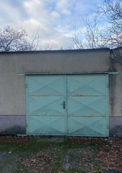 Világoskék ajtós garázskapu és lehullott levelek Szelicén.