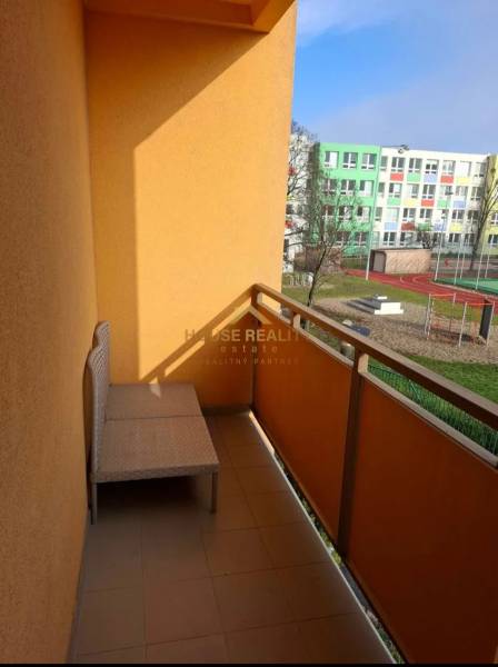 Erkély kilátással az iskolai területre és sportpályákra egy 4 szobás lakásból.