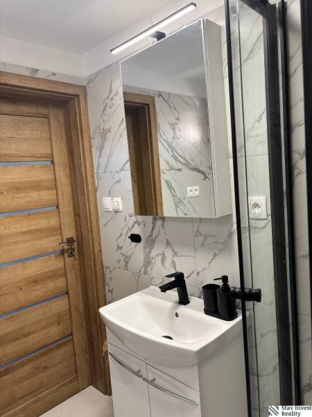 Fürdőszoba faajtóval, mosdóval és tükörrel egy családi házban.