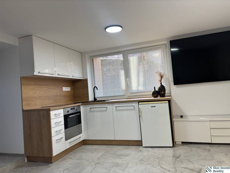 Konyha családi házban fehér szekrényekkel és fa dekorációval.